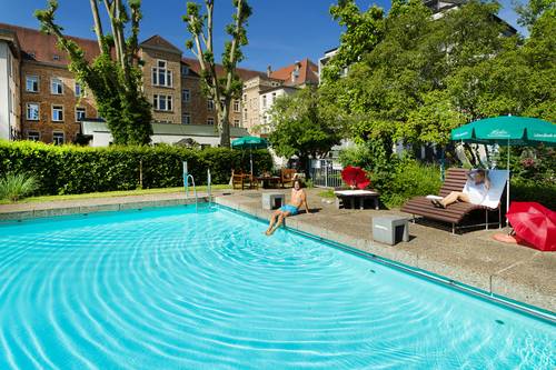 Mann sitzt am Beckenrand des Außenschwimmbades im Bildungshaus St. Bernhard
